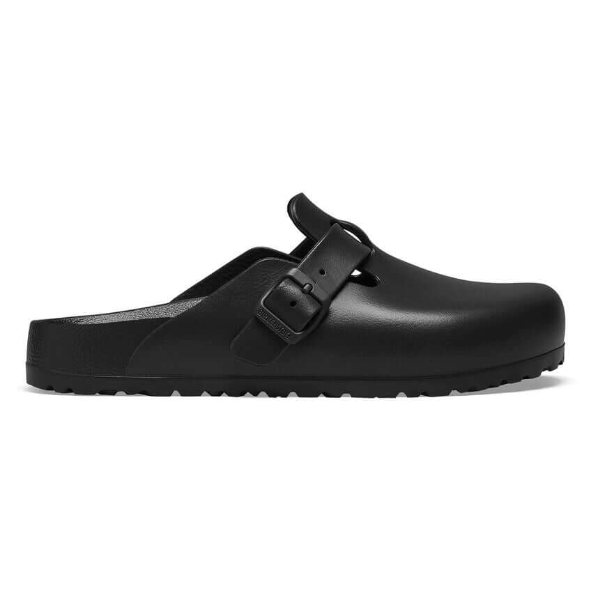 Black slip-on clog-style sandal with a buckle closure and textured sole.
