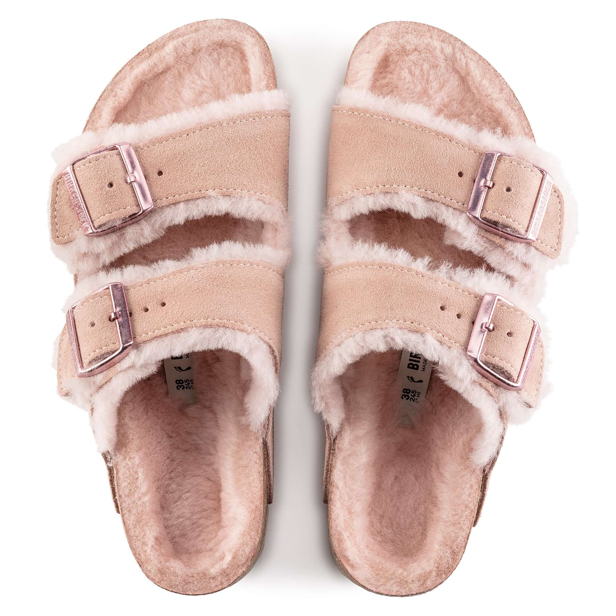 Top view of pink fuzzy sandals with double buckle straps for women.