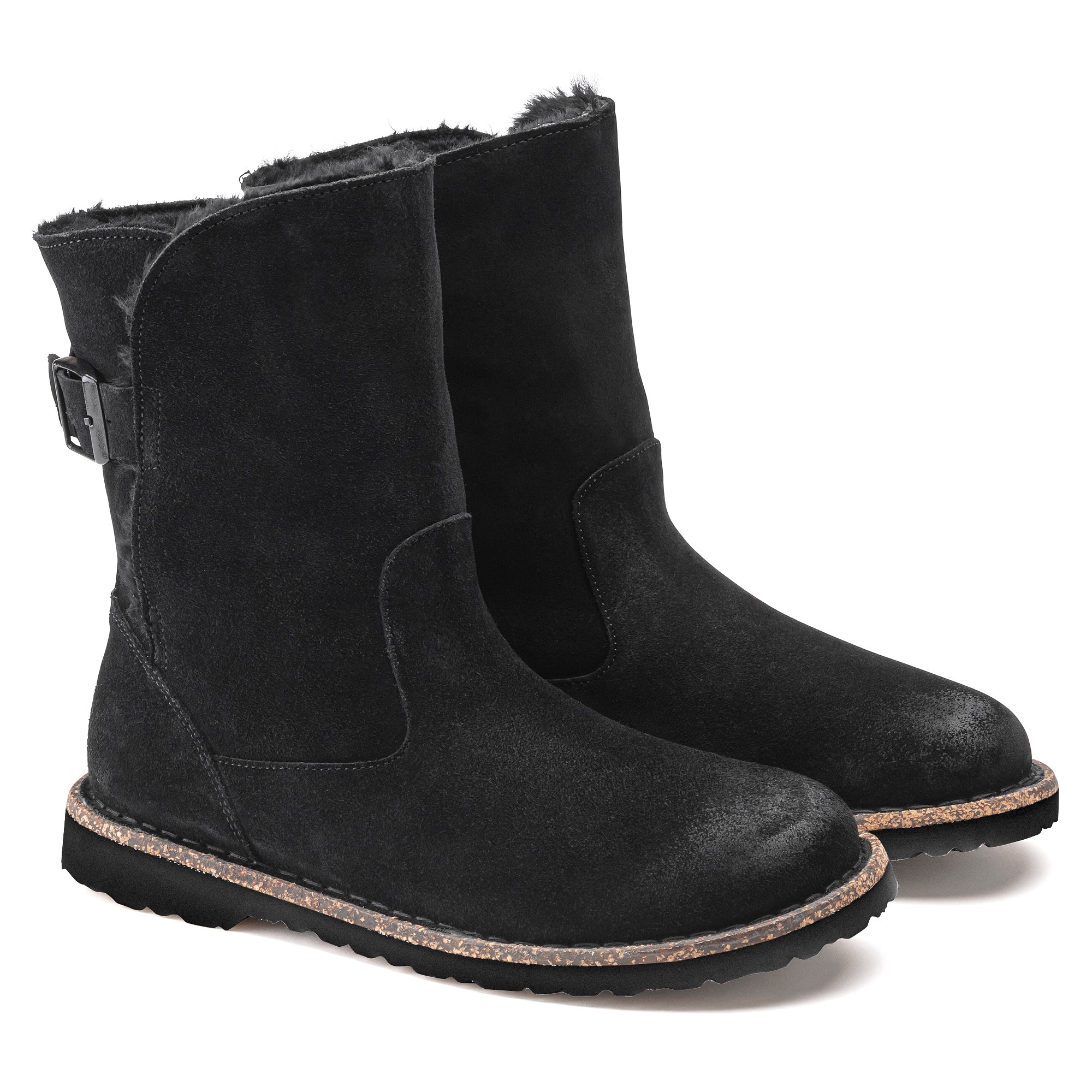 Black suede winter boots with fur lining and buckle detail on wooden sole.