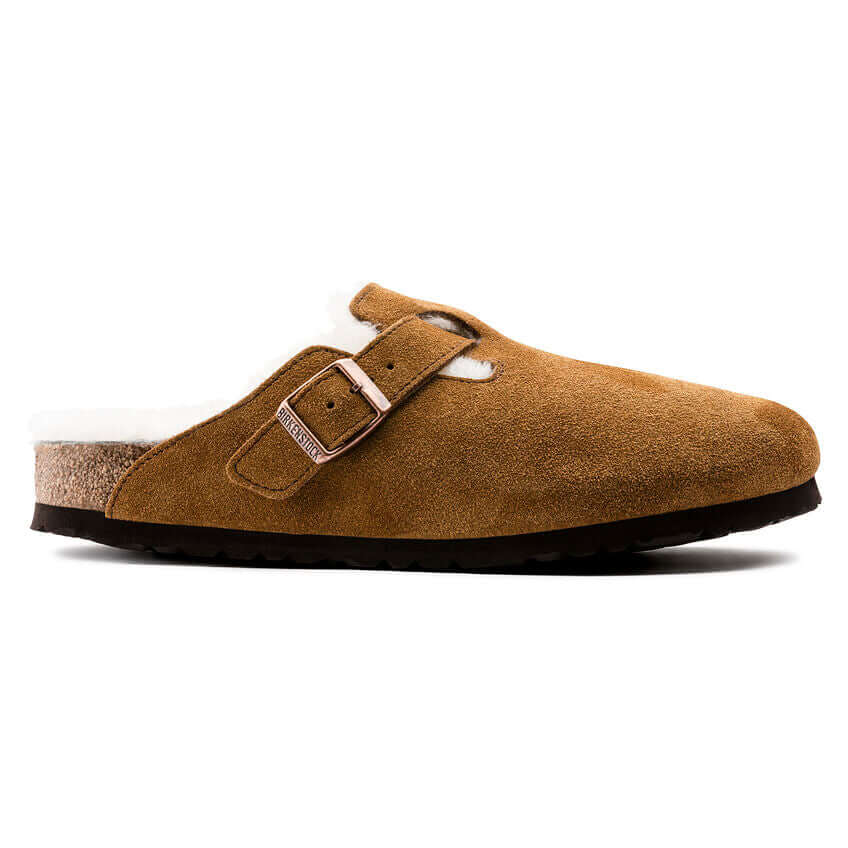 Brown suede slip-on clog with buckle and cozy lining on white background.