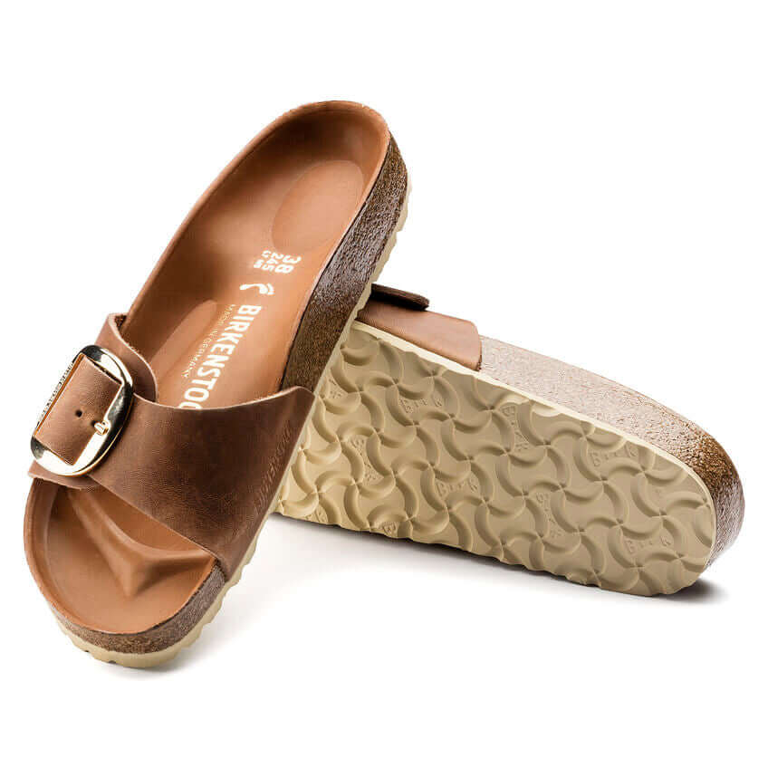 Brown Birkenstock sandals with buckle detailing and textured soles.