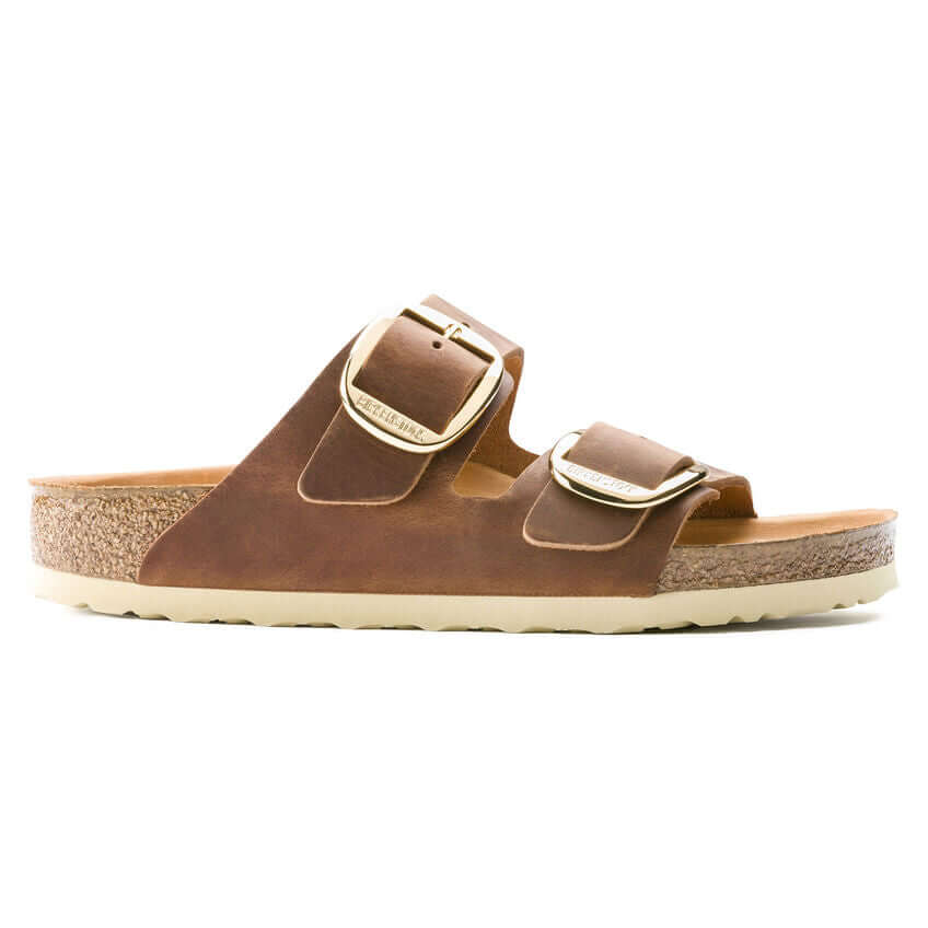 Brown cork footbed sandal with dual adjustable buckles and white sole.
