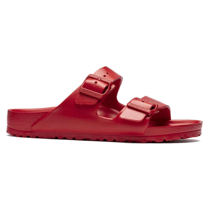 Red two-strap rubber sandals with buckles on white background
