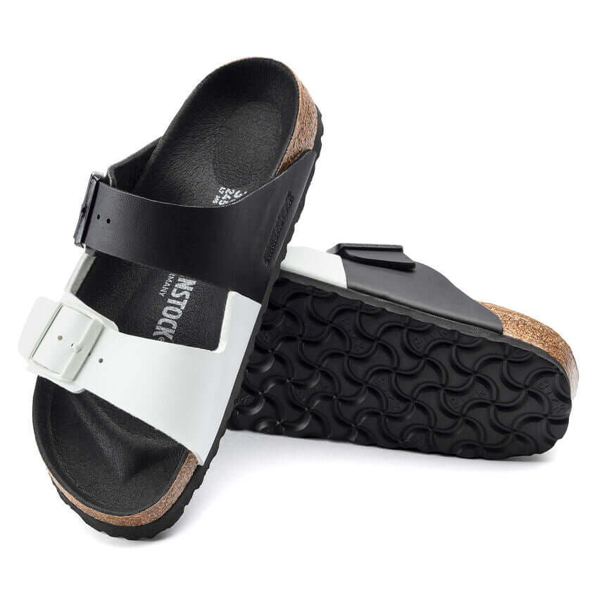 Comfortable black and white ergonomic sandals with a textured sole and adjustable straps for enhanced fit and support