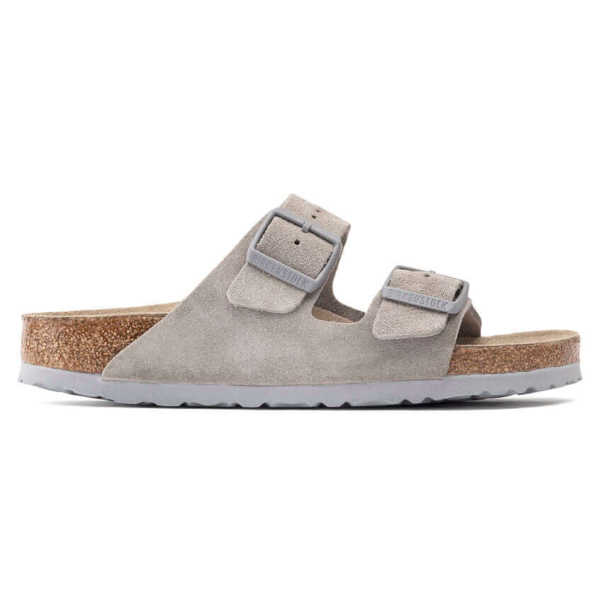 Grey suede two-strap sandals with cork footbed and adjustable buckles on a white background.