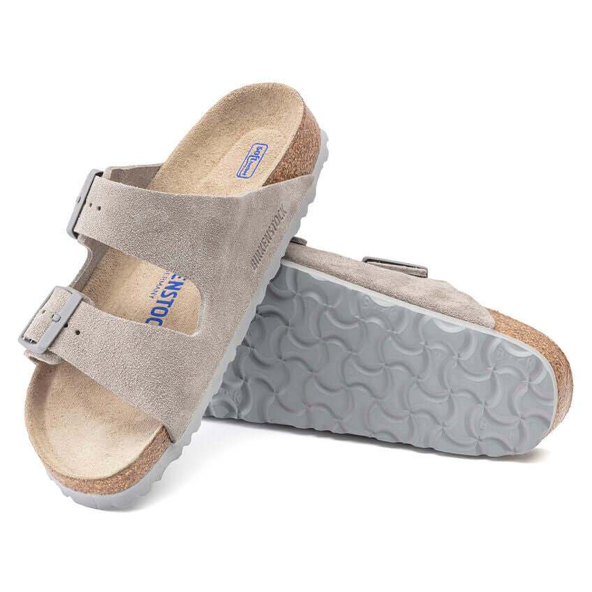 Gray suede Birkenstock sandals with adjustable straps and textured soles.