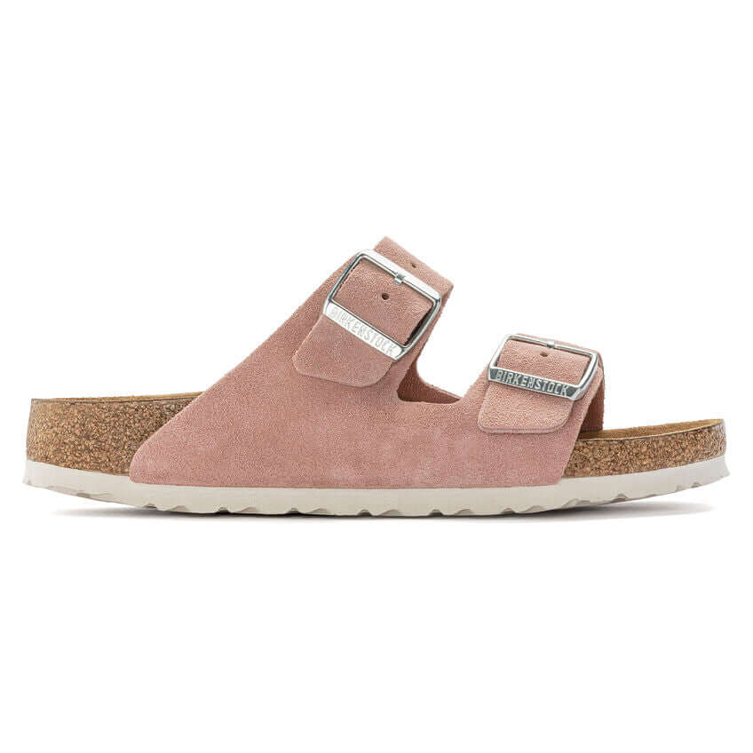 Pink suede double-strap sandals with cork sole and metallic buckles.