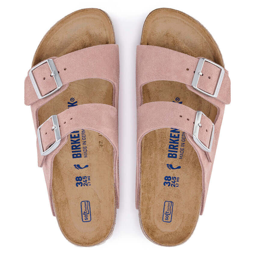 Pink Birkenstock sandals with two adjustable straps and cork soles, top view.